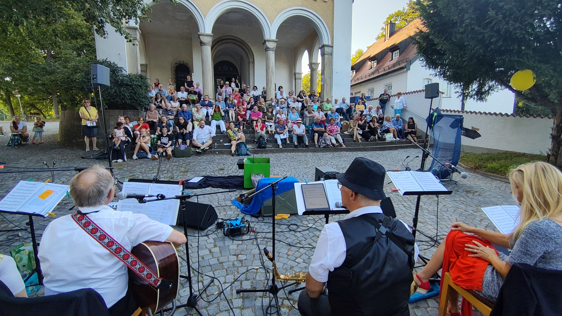 Blick auf die Besucher beim fünften Mitsingkonzert auf den Stufen der Bergkirche Hl. Dreifaltigkeit